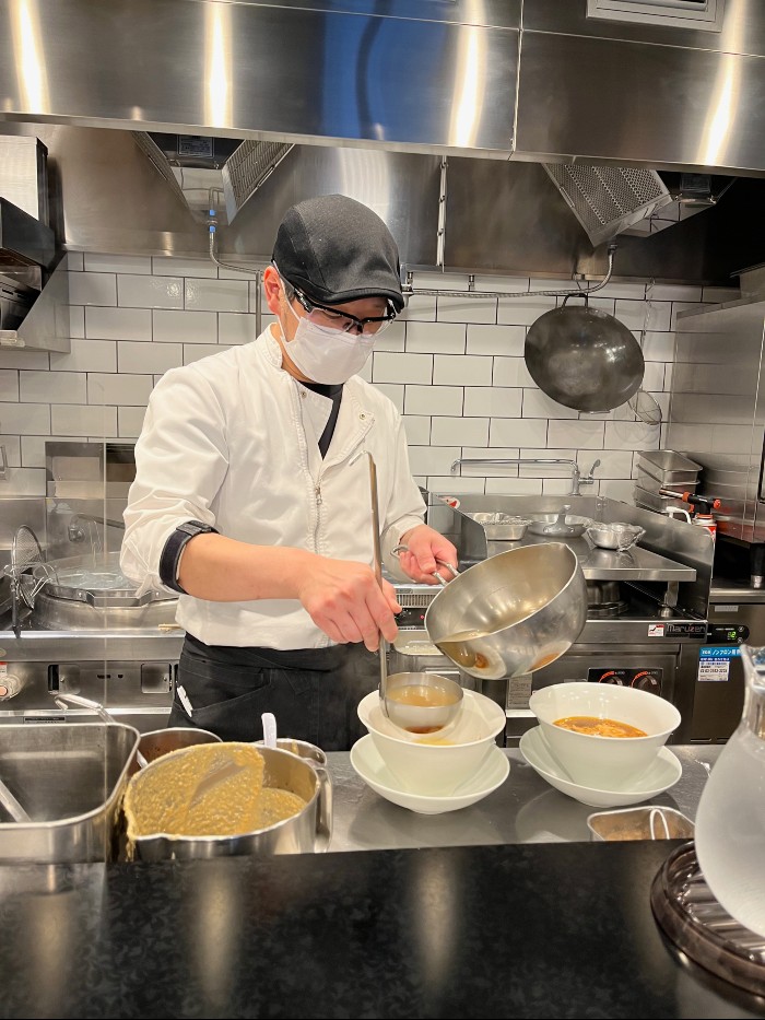 Making the tantanmen for the guests seated next to me
